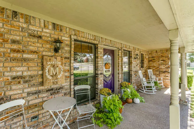 Brick front porch with rocking chairs staged for curb appeal on a Burleson, Texas listing