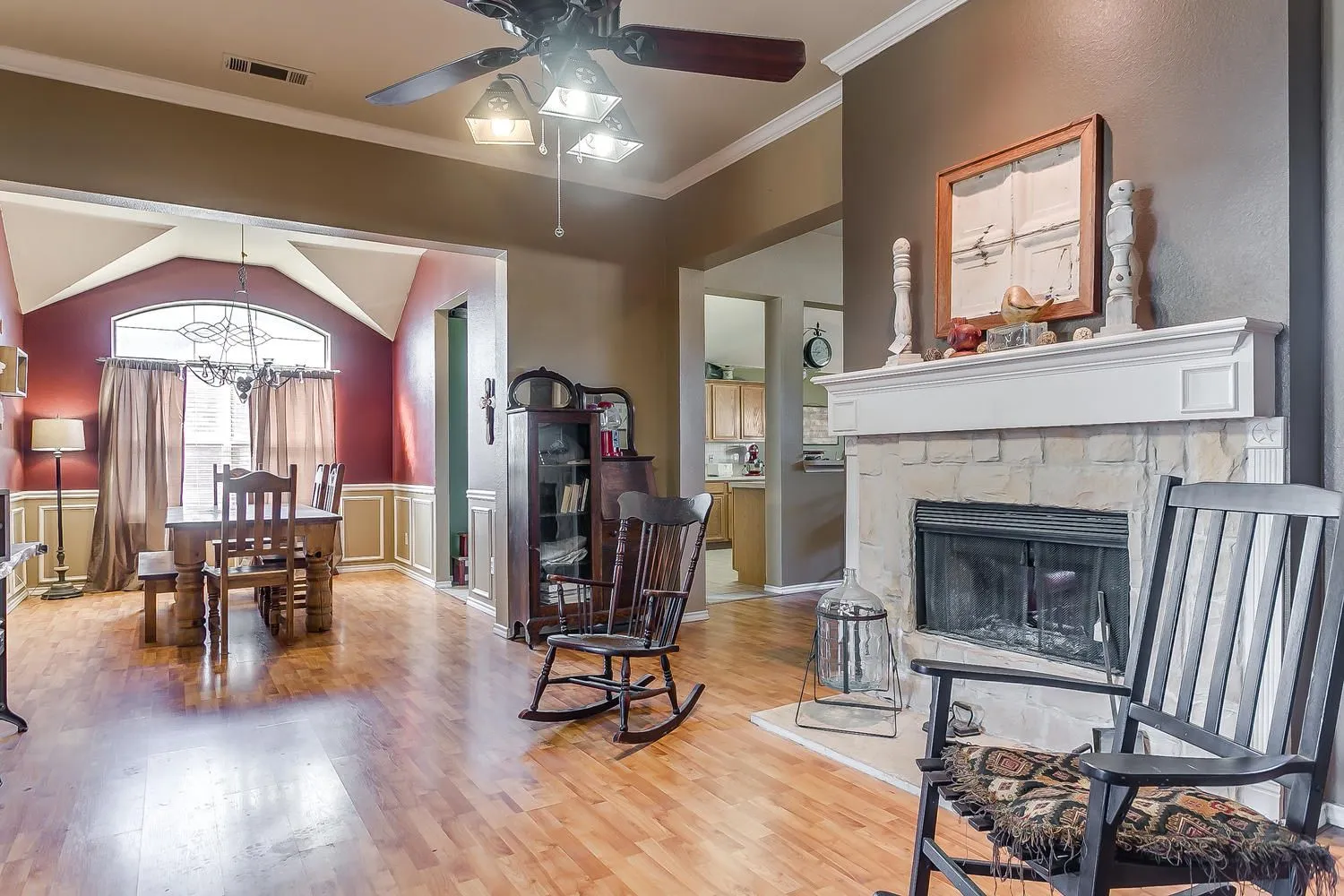 Living and dining area staged to highlight the stone fireplace on a recent local listing
