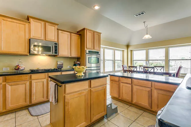Updated kitchen with wood cabinetry in a Tarrant County home shown to buyers
