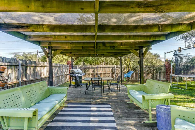 Covered patio staged with seating to showcase outdoor living space on a Tarrant County listing