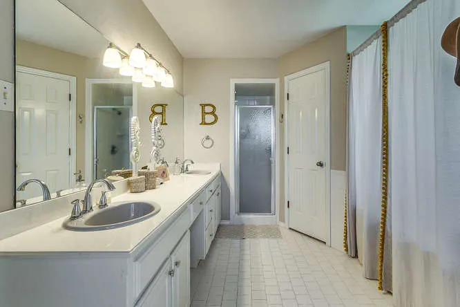 Updated bathroom with double vanity in a Johnson County home represented by Team Hoover Realty Group