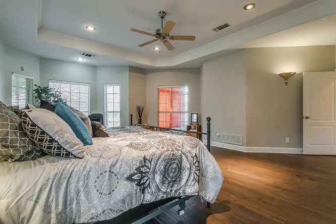 Primary bedroom with a tray ceiling in a Tarrant County home listed by Team Hoover Realty Group